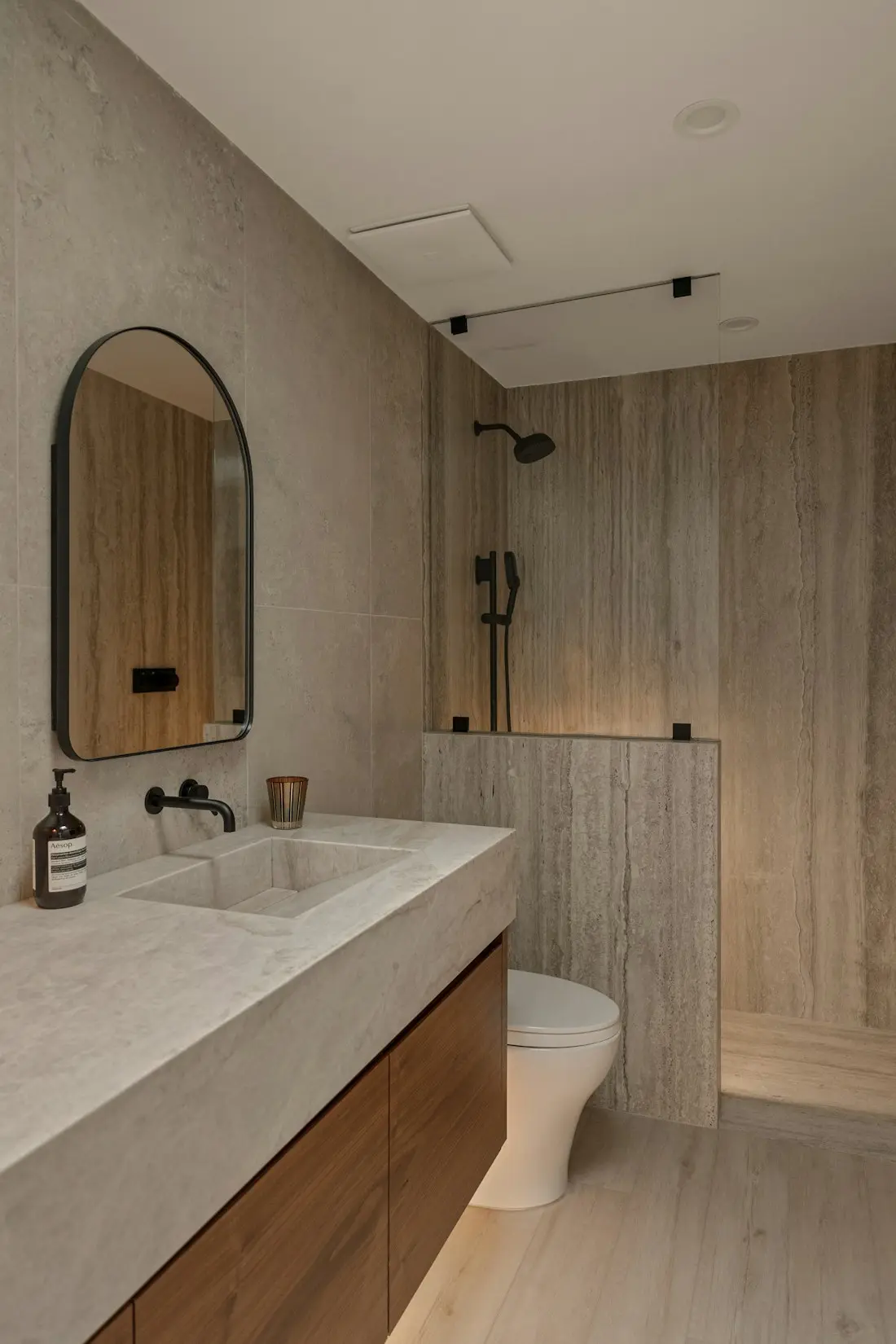 Guest bath in warm stone — Limestone-look porcelain, 24×48 in.