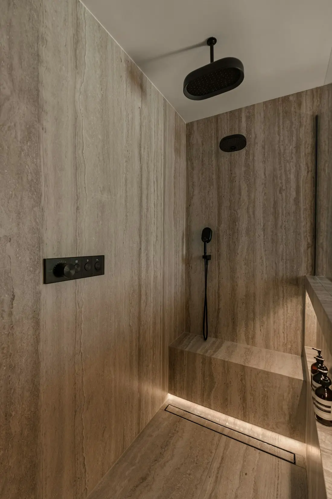 Curbless walk-in shower — Travertine-look porcelain, linear drain